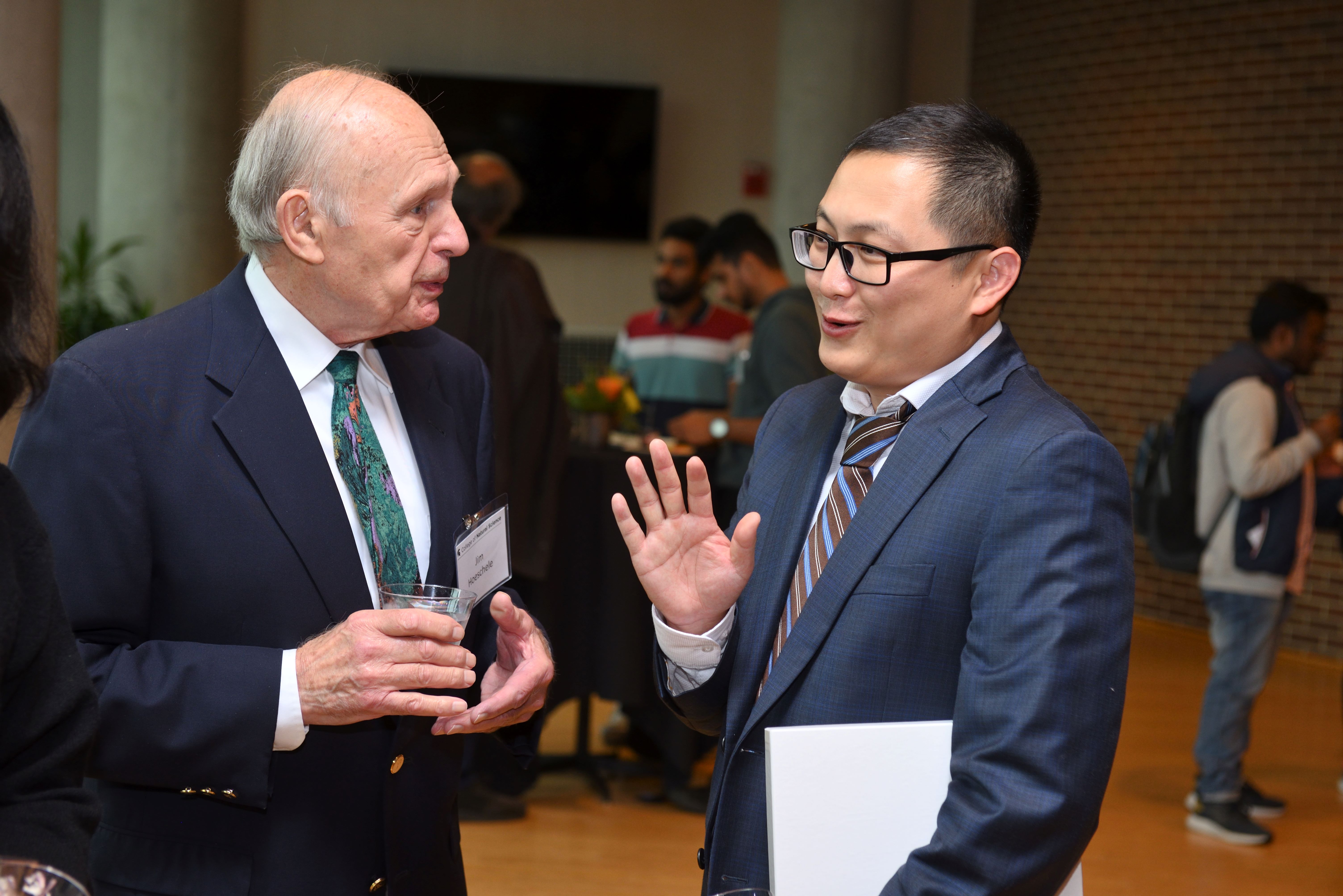 Tuo Wang, associate professor of chemistry and the inaugural Carl H. Brubaker, Jr. Endowed Professor, talks with Jim Hoeschele, who established the Brubaker professorship, at a reception following his investiture ceremony. Photo Credit: Harley Seeley.