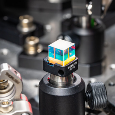Close up of a glass cube on a laser instrumentation table.