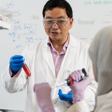 Huang Group researcher with blue gloves