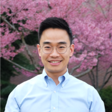 Prof. Kim posing in front of blooming tree.