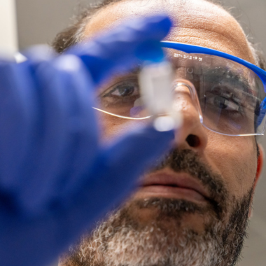 Dr. Rahman in lab coat and gloves